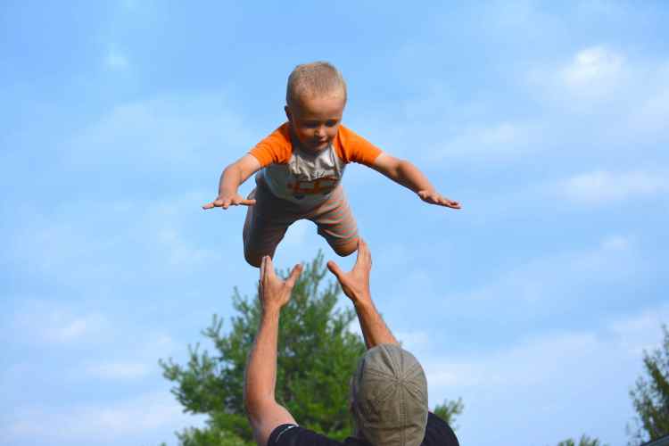 Eli, 3, lands in his Dad's hands after a flying high.